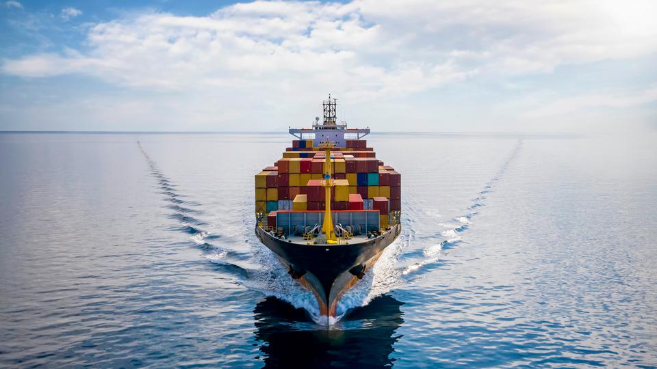 Flygfoto över ett lastat containerfartyg som färdas över ett hav