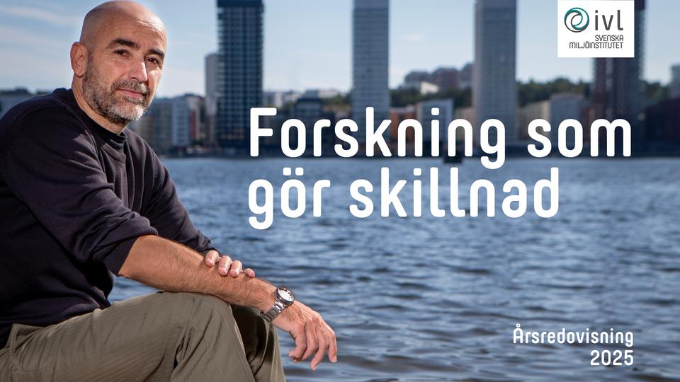 En man sitter vid vattnet i fondens syns höga fastigheter.