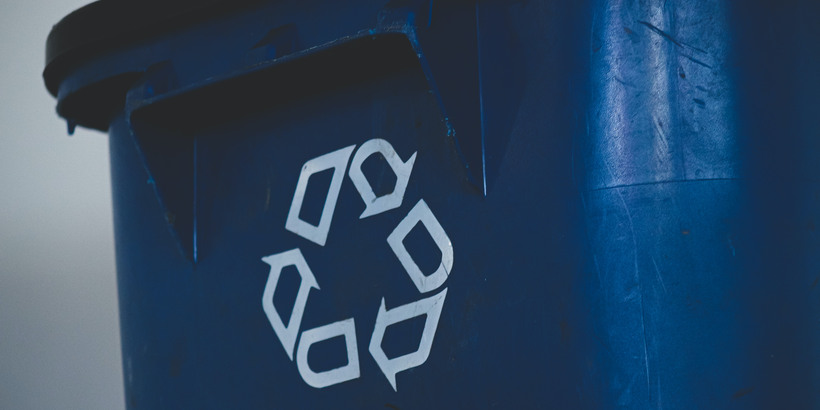 återvinningsymbol på en blå soptunna