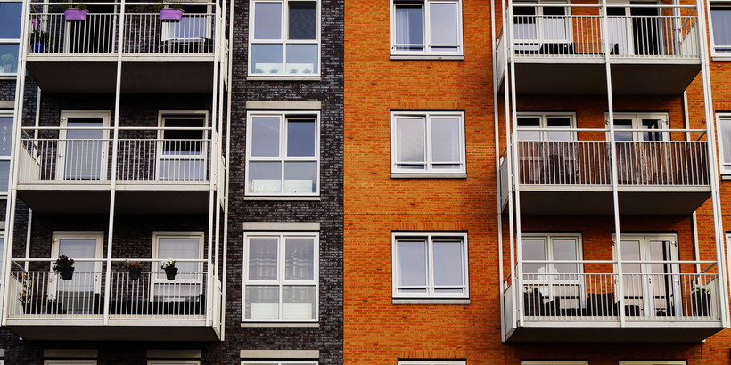 Lägenhetshus i orange och blått med vita balkonger