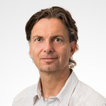 En man i vit skjorta poserar för att bli fotograferad.