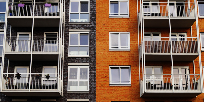 Lägenhetshus i orange och blått med vita balkonger