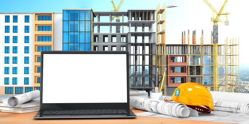 Desktop with an open laptop, construction drawings in rolls, construction helmet on the background of construction. 3D illustration