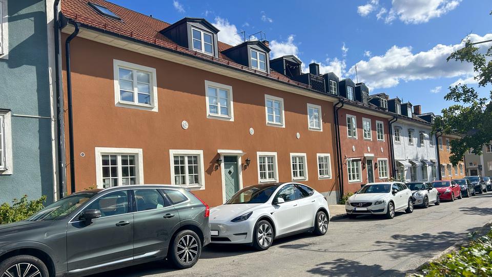 En gata där det står bilar parkerade utefter en trottoar.