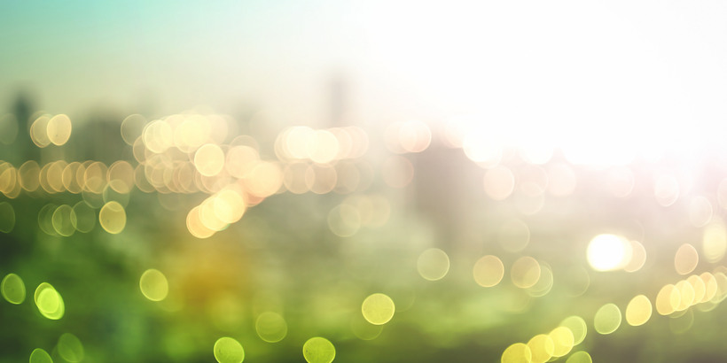 World environment day concept: Abstract blur colorful bokeh city lights over green nature autumn sunrise background