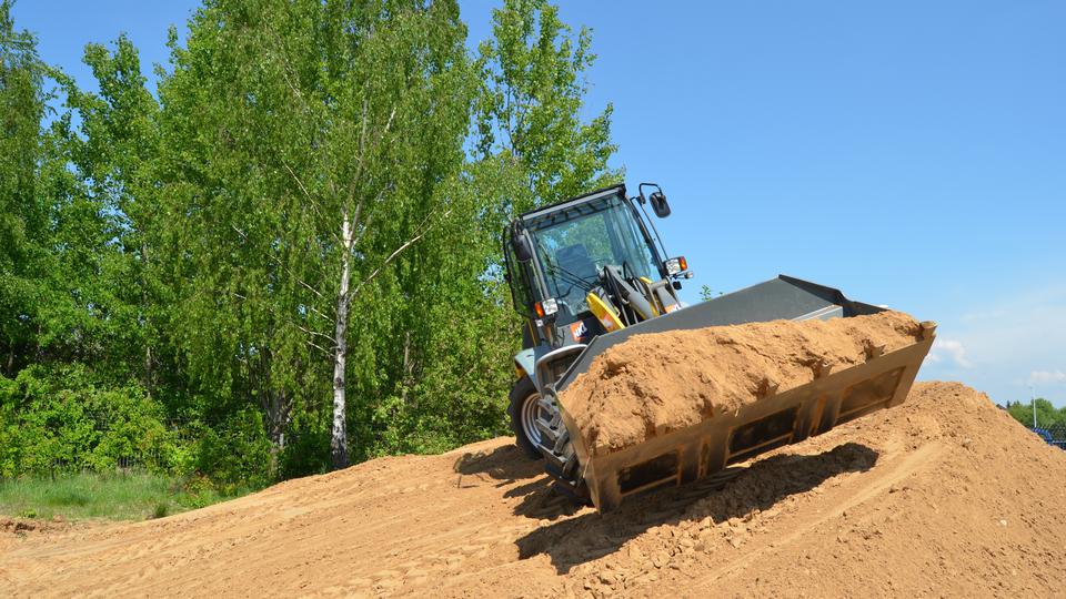 Wheel loader transporting excavated soil at a construction site.