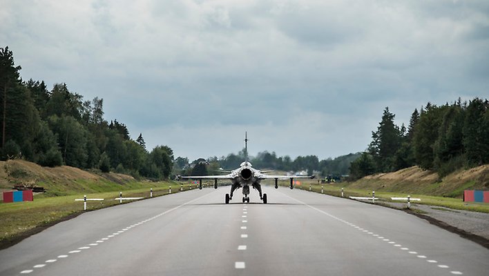 Ett militärflygplan står på vägbana